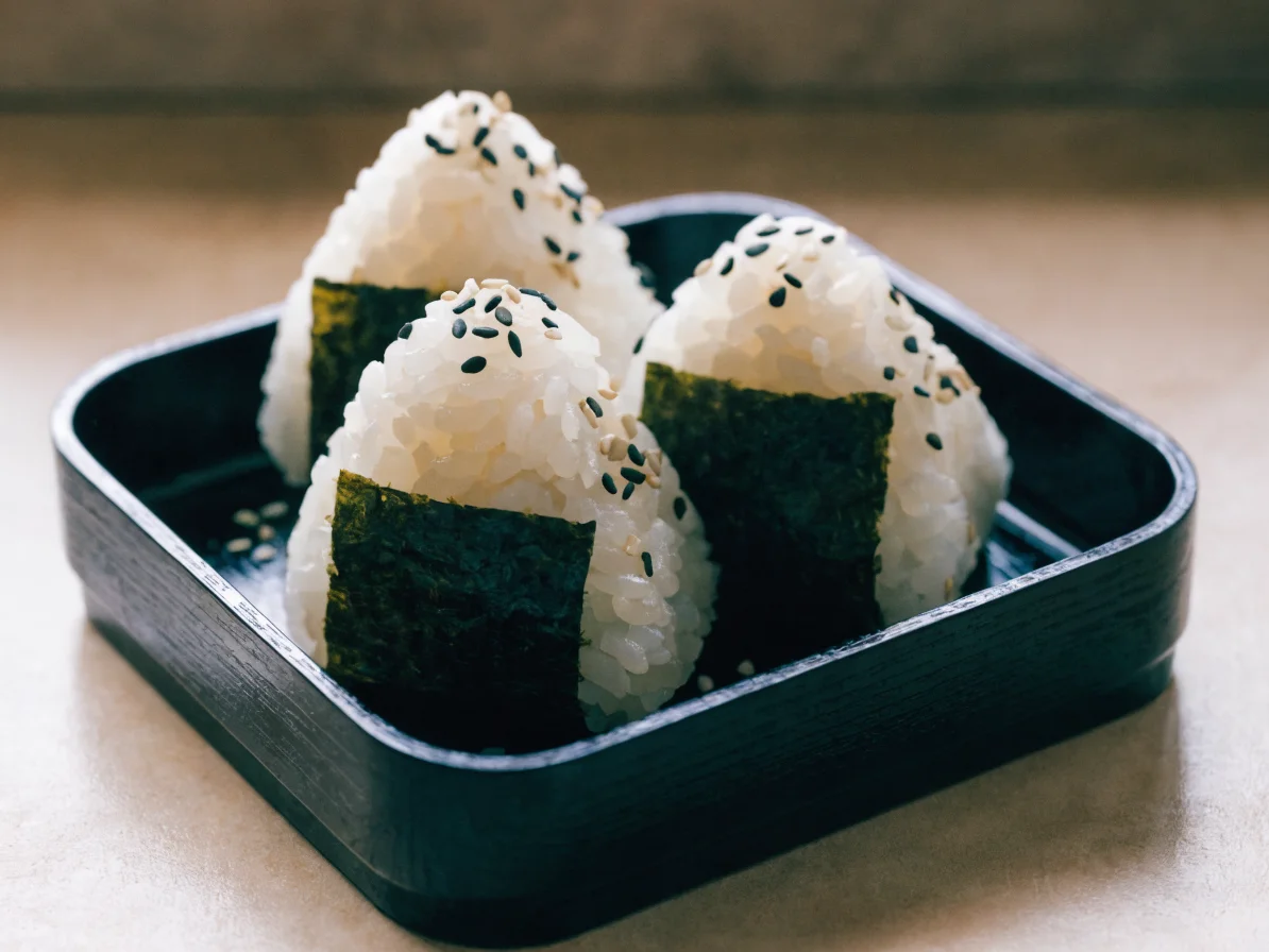 Onigiri triangulaires enveloppés de nori, riz assaisonné visible